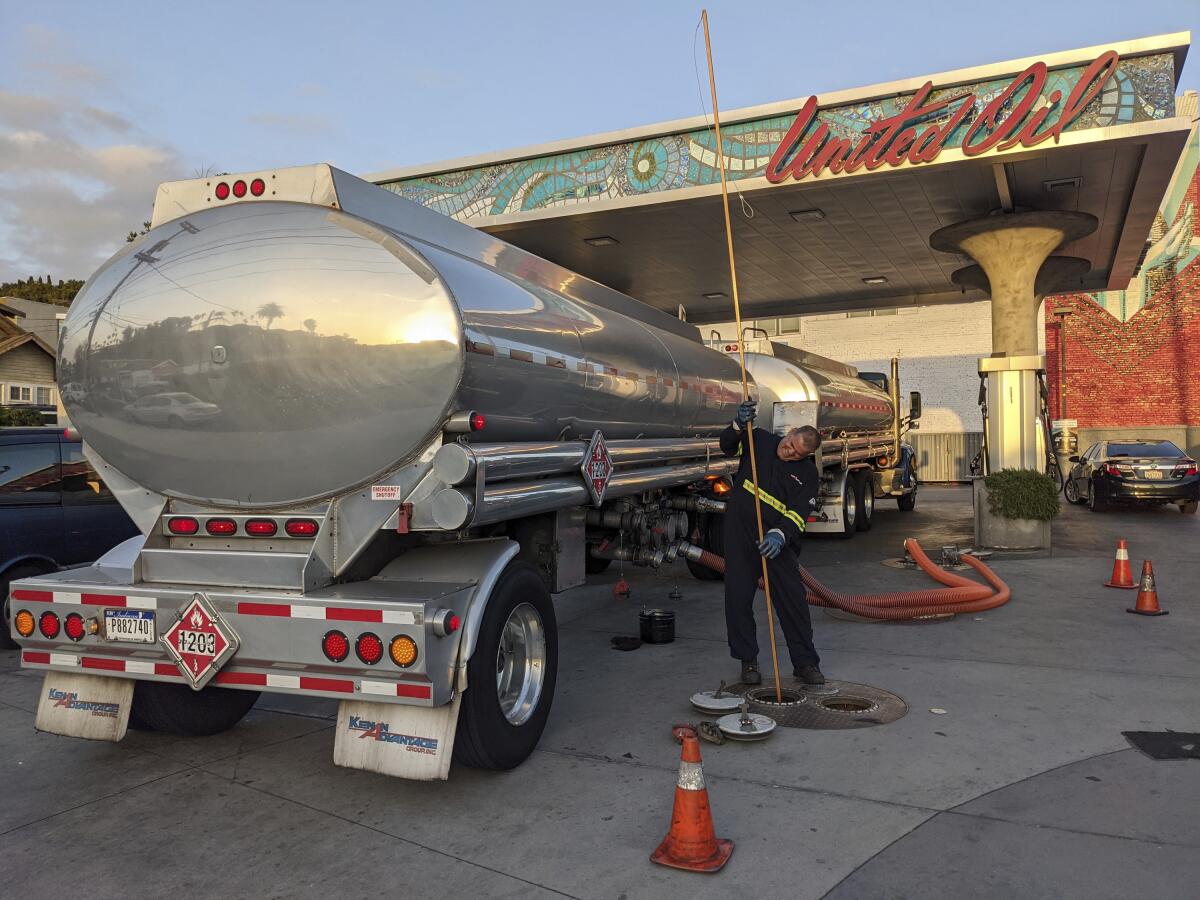 In this May 20, 2021 photo, a fuel truck driver checks the gasoline tank level at a United Oil gas station in Sunset Blvd., in Los Angeles. The average U.S. price of regular-grade gasoline jumped 8 cents over the past two weeks, to $3.10 per gallon. Industry analyst Trilby Lundberg of the Lundberg Survey said Sunday, May 23, 2021 that the increase is attributed to supply disruption from the 10-day shutdown of the Colonial Pipeline following a cyberattack, and a rise in prices for corn, a key ingredient in corn-based ethanol that must be blended by refiners into gasoline. (AP Photo/Damian Dovarganes)