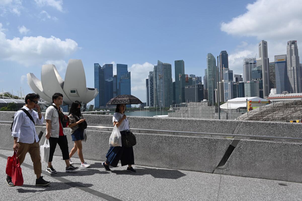 People walk past Marina Bay Sands resort in Singapore
