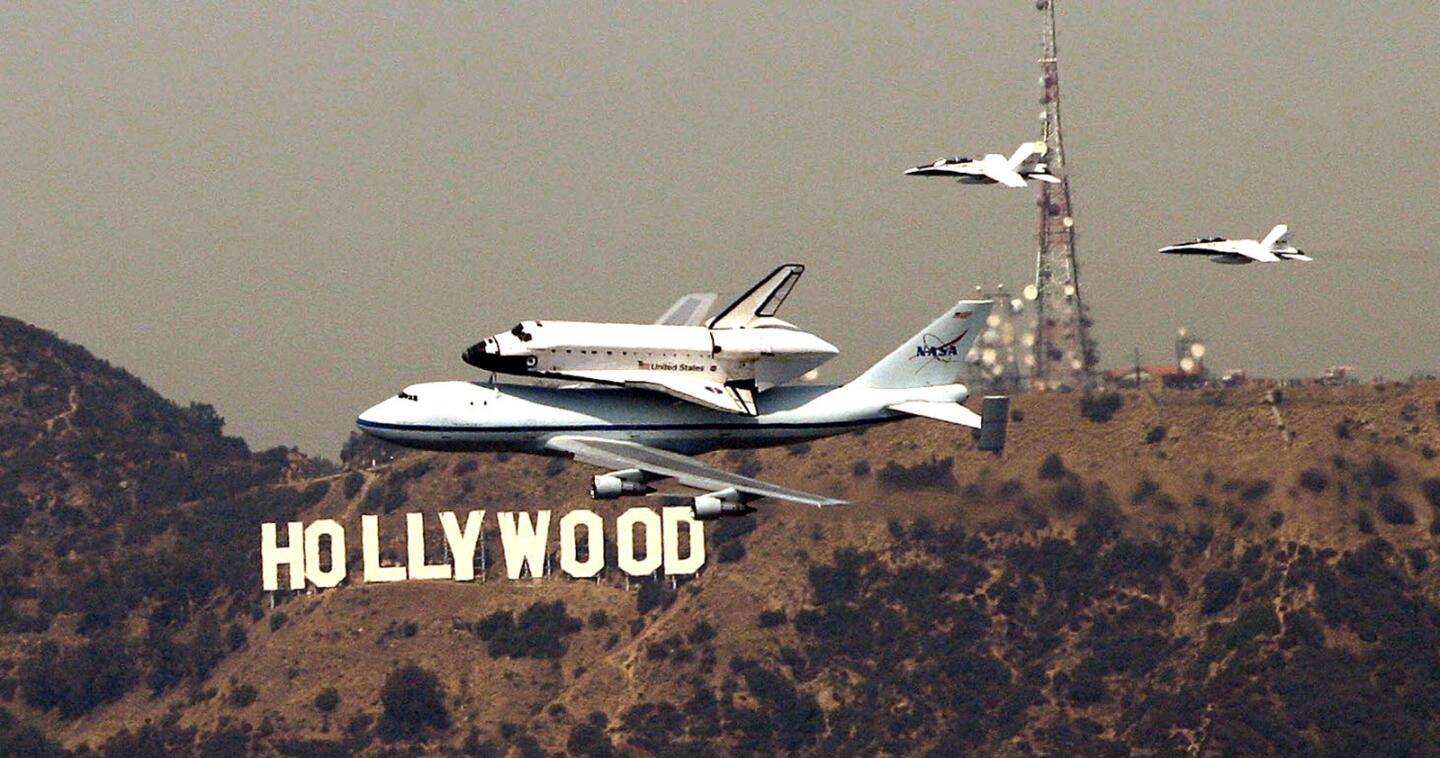 The space shuttle Endeavour passes the Hollywood sign before landing at Los Angeles International Airport on Sept. 21, 2012.