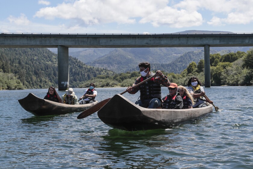 Yurok guides Zechariah Gabel, front, Sammy Gensaw, right and Jon-Luke Gensaw, left, paddle tourists along the Klamath River.