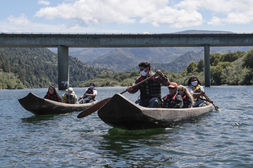 Klamath, CA, Thursday, June 10, 2021 - Yurok guides Zechariah Gabel, front, Sammy Gensaw, right and Jon-Luke Gensaw, left, paddle tourists along the Klamath River in traditional canoes hand crafted from Redwood trees. (Robert Gauthier/Los Angeles Times)