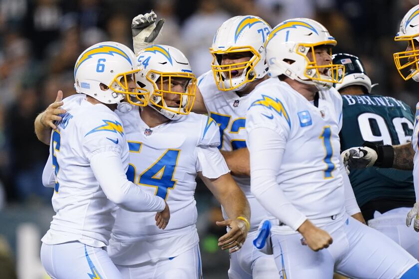 Los Angeles Chargers' Dustin Hopkins, left, celebrates his game-winning field goal.