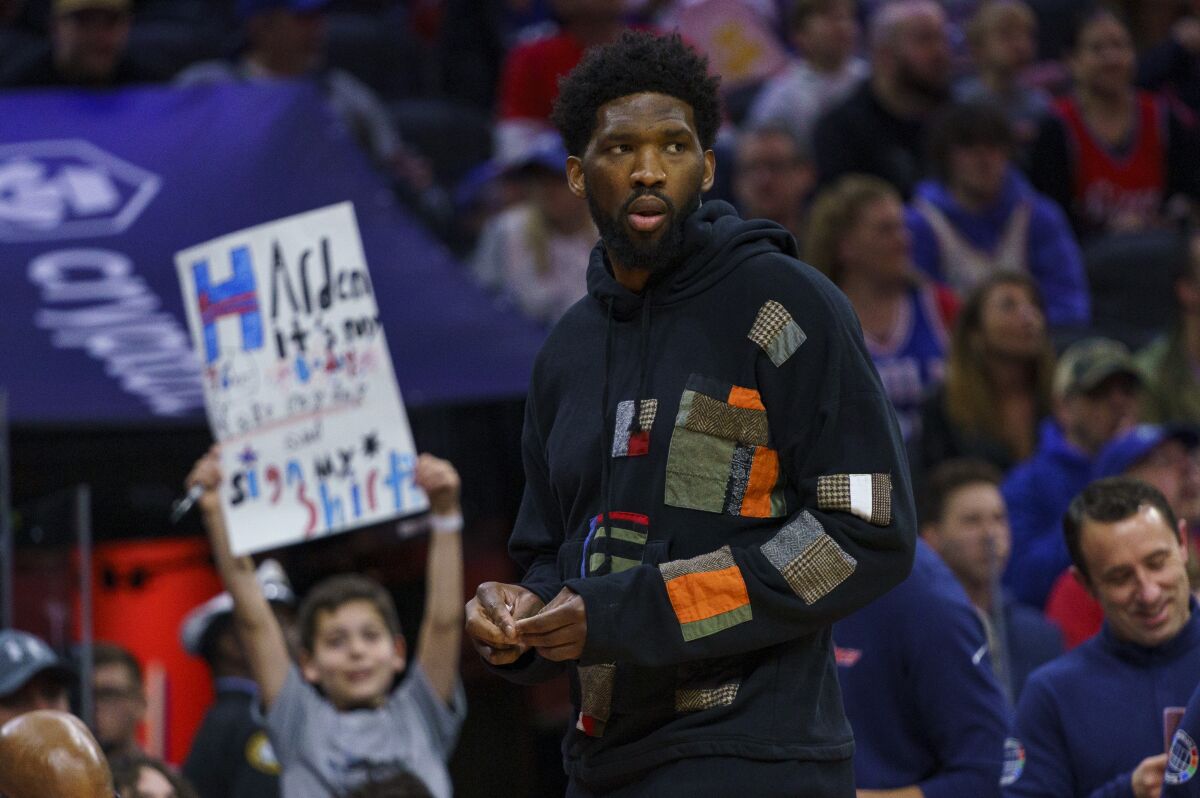 Philadelphia 76ers' Joel Embiid looks on as he has the night off during the first half of an NBA basketball game against the Detroit Pistons, Sunday, April 10, 2022, in Philadelphia. (AP Photo/Chris Szagola)