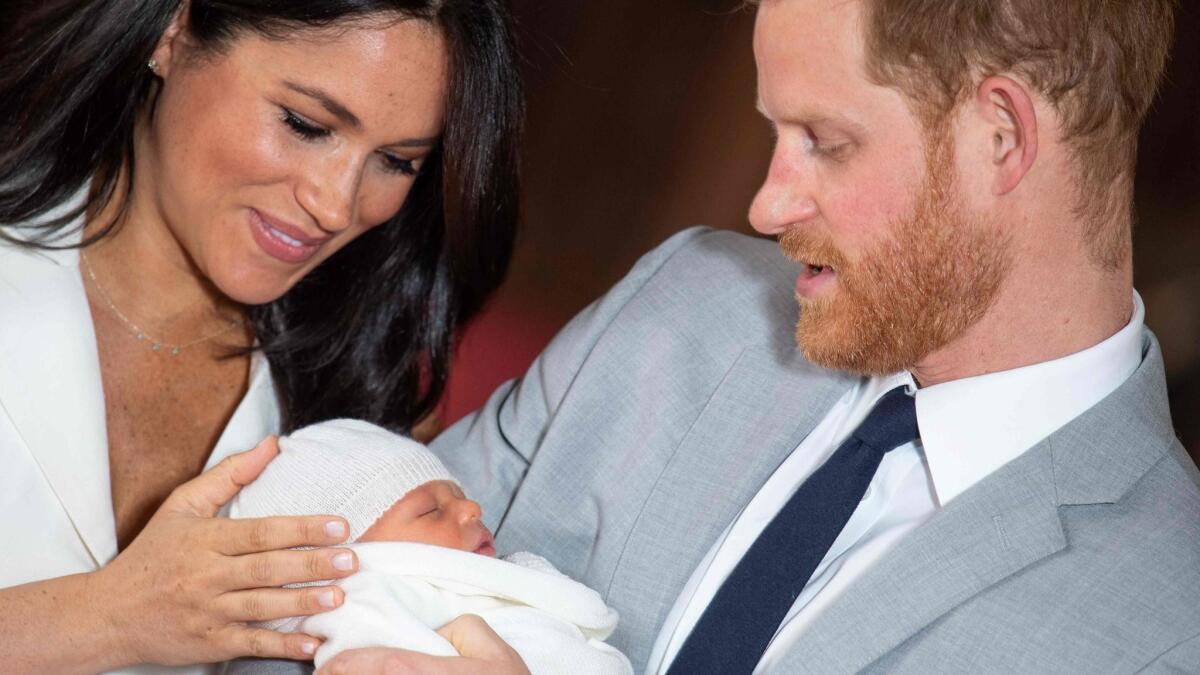 Meghan, Duchess of Sussex, left, and Prince Harry, Duke of Sussex, with their son, Archie Harrison Mountbatten-Windsor, in St. George's Hall at Windsor Castle on May 8.