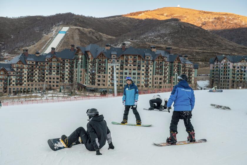 Snowboarders practice in the beginners area at the Thaiwoo Ski Resort in Zhangjiakou, China, in December.