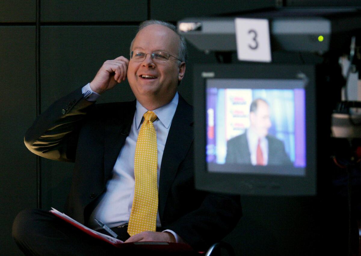 Republican strategist Karl Rove with Democratic campaign consultant David Axelrod on the television screen in 2008.