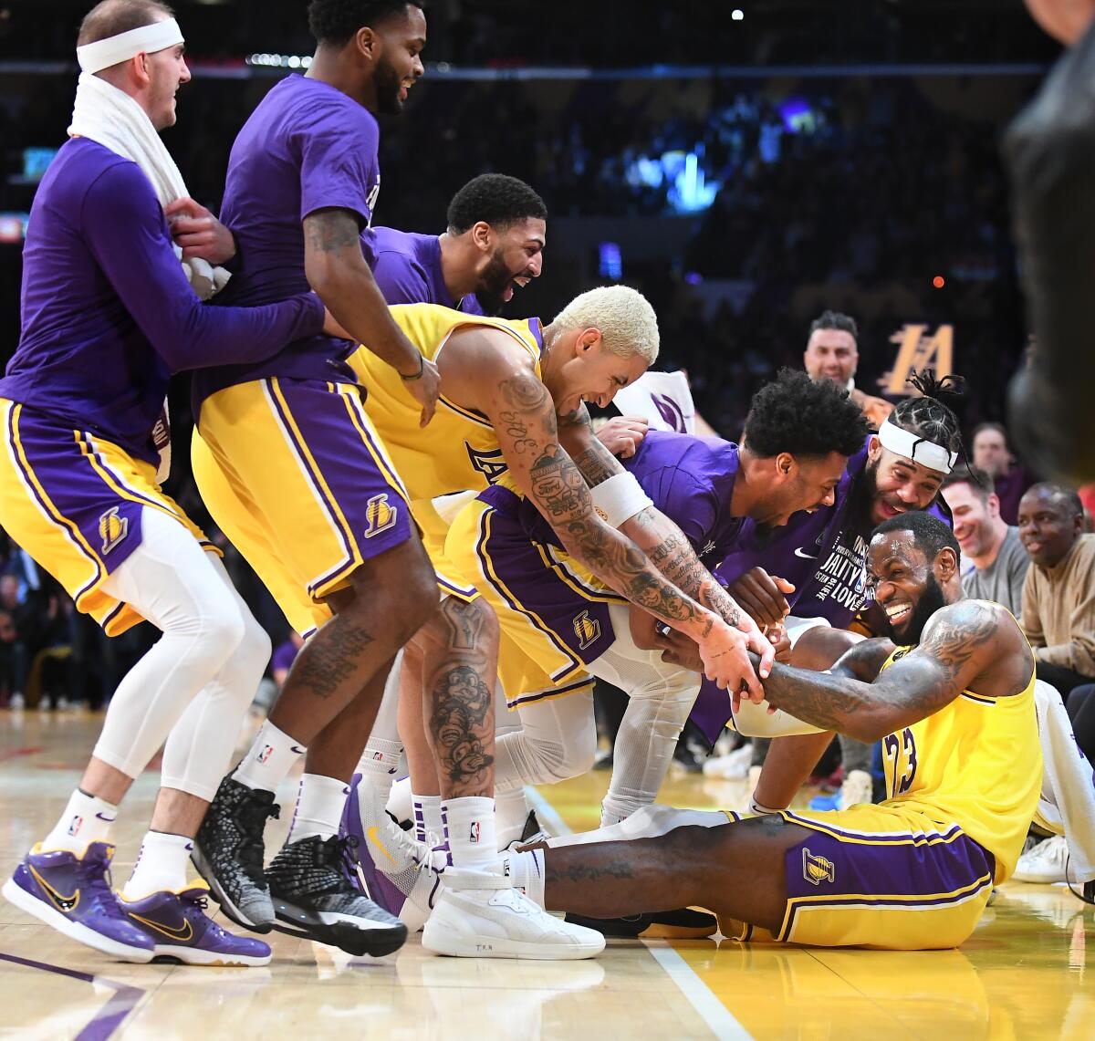 LeBron James is mobbed by his Lakers teammates after hitting a three-pointer against the Spurs on Feb. 4 at Staples Center.