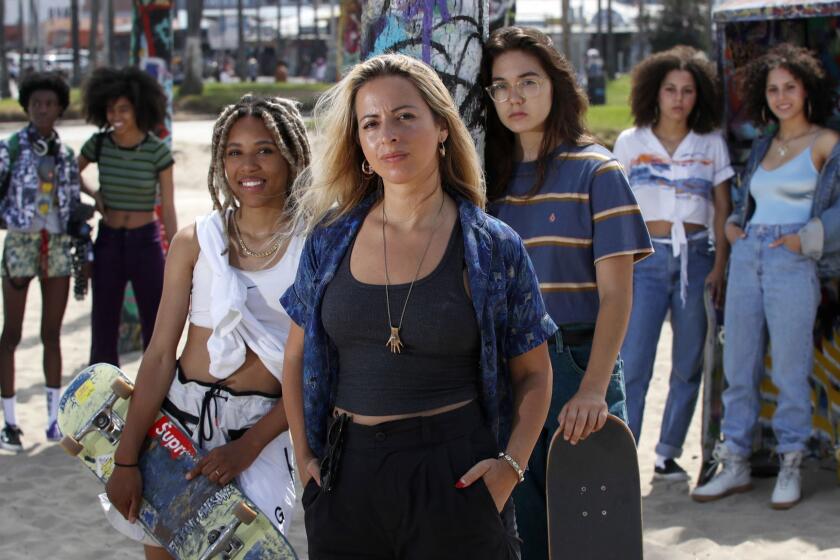 VENICE BEACH, CALIF. - JULY 16, 2018. Director Crystal Moselle, center, with actors DeDe Lovelace, center left, and Rachelle Vinberg, center right, and the rest of the cast of 'Skate Kitchen,' a film about a gang of skateboarding girls who form a friendship. (Luis Sinco/Los Angeles Times)