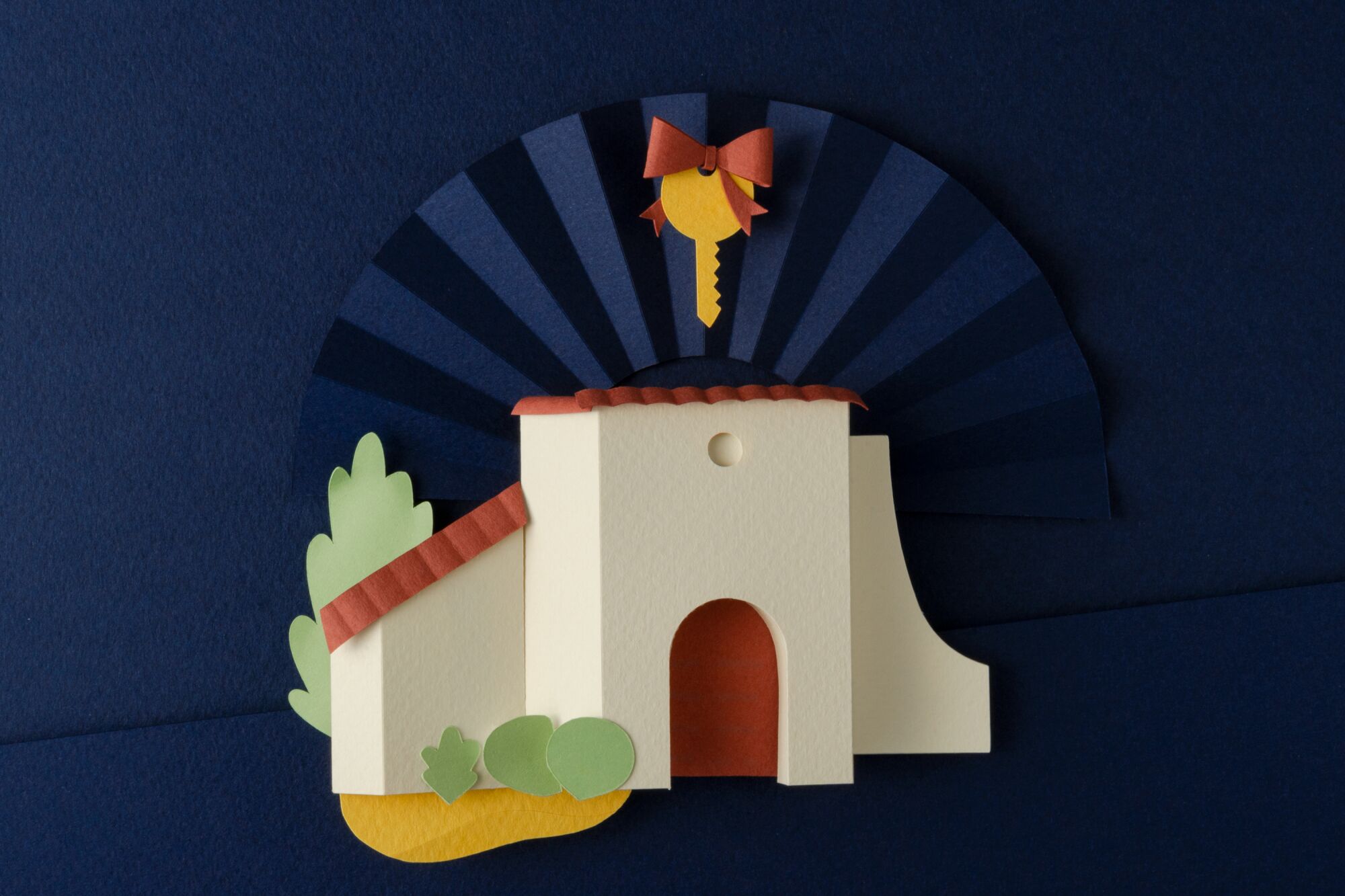 A model of a Spanish style home with a key floating above it.