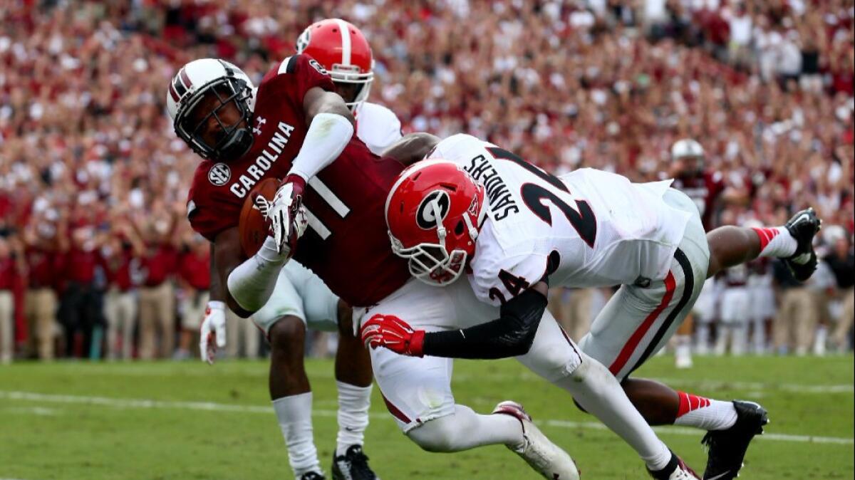 South Carolina receiver Pharoh Cooper scores as two Georgia defenders try to bring him down during a game on Sept. 13, 2014.