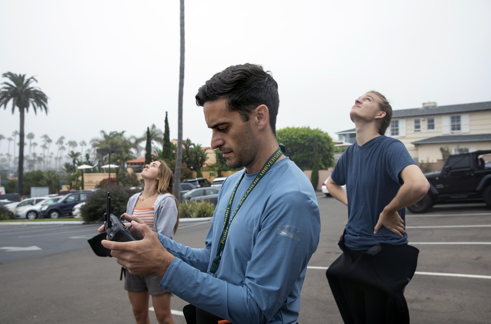 Professor Andrew Nosal (center) and students Caroline Saple and Josh Gailey fly a drone to look at leopard sharks.