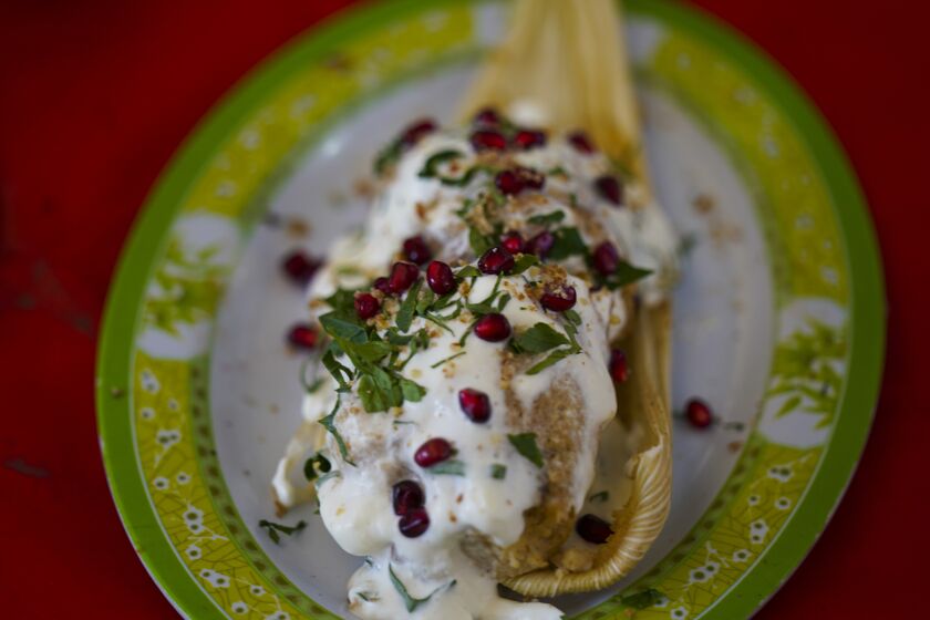 A Chiles en Nogada style tamal is displayed during the tamales fair at the Ixtapalapa neighborhood of Mexico City, Friday, Jan. 27, 2023. Chiles en nogada is a Mexican dish of poblano chiles stuffed with picadillo topped with a walnut-based cream sauce called nogada, pomegranate seeds and parsley, and it is typically served at room temperature. It is widely considered a national dish of Mexico. (AP Photo/Fernando Llano)