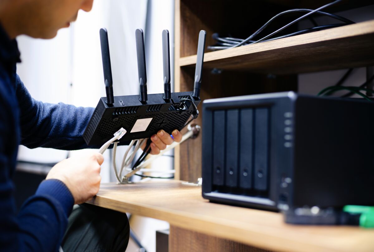 A man relocates a router to a spot in the middle of his home.