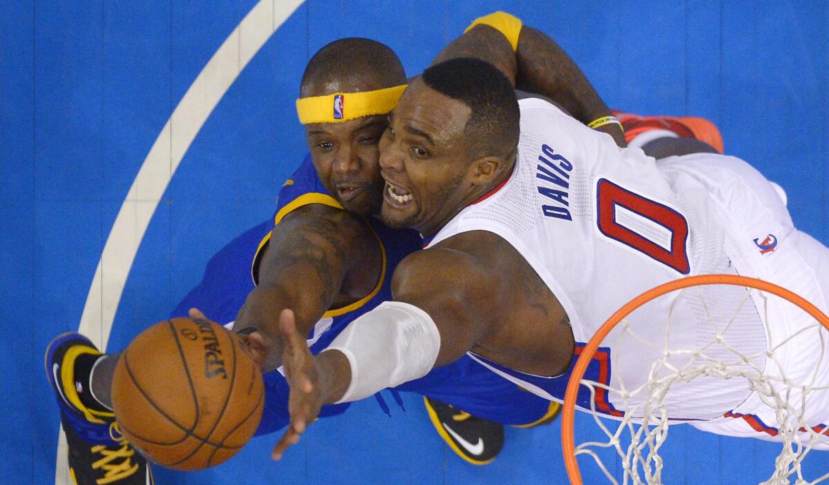 Clippers power forward Glen Davis, right, battles Golden State Warriors center Jermaine O'Neal for a rebound during Saturday's playoff opener. Davis has played a valuable role in bolstering the productivity of the Clippers' bench.