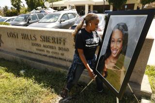 CALABASAS, CA - SEPTEMBER 17, 2019 Kim Howard who works in mental health places a photo of Mitrice Richardson at the Lost Hills Sheriff Station in Calabasas for a memorial and press conference on the tenth anniversary of the disappearance of Mitrice Richardson, who disappeared following her release from the Malibu/Lost Hills Sheriff's Station in 2009 and whose body was found in August 2010. Former friends and colleagues placed the sunflowers at the Lost Hills Sheriff Station site where she was last seen. (Al Seib / Los Angeles Times)