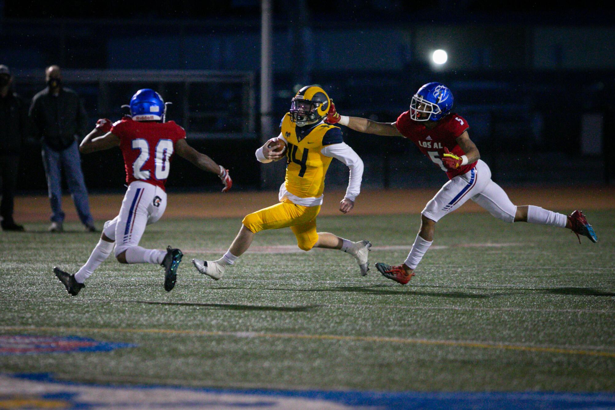 Los Alamitos players close in on Millikan quarterback Will Madonna as he carries the ball.