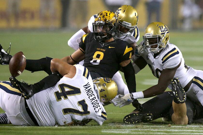 UCLA defensive tackle Eddie Vanderdoes (47) and teammates force Arizona State running back D.J. Foster to fumble during last week's game.