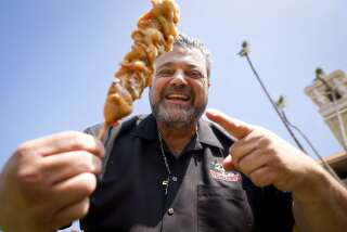"Chicken Charlie" Boghosian shows off his deep-fried funnel cake dog.