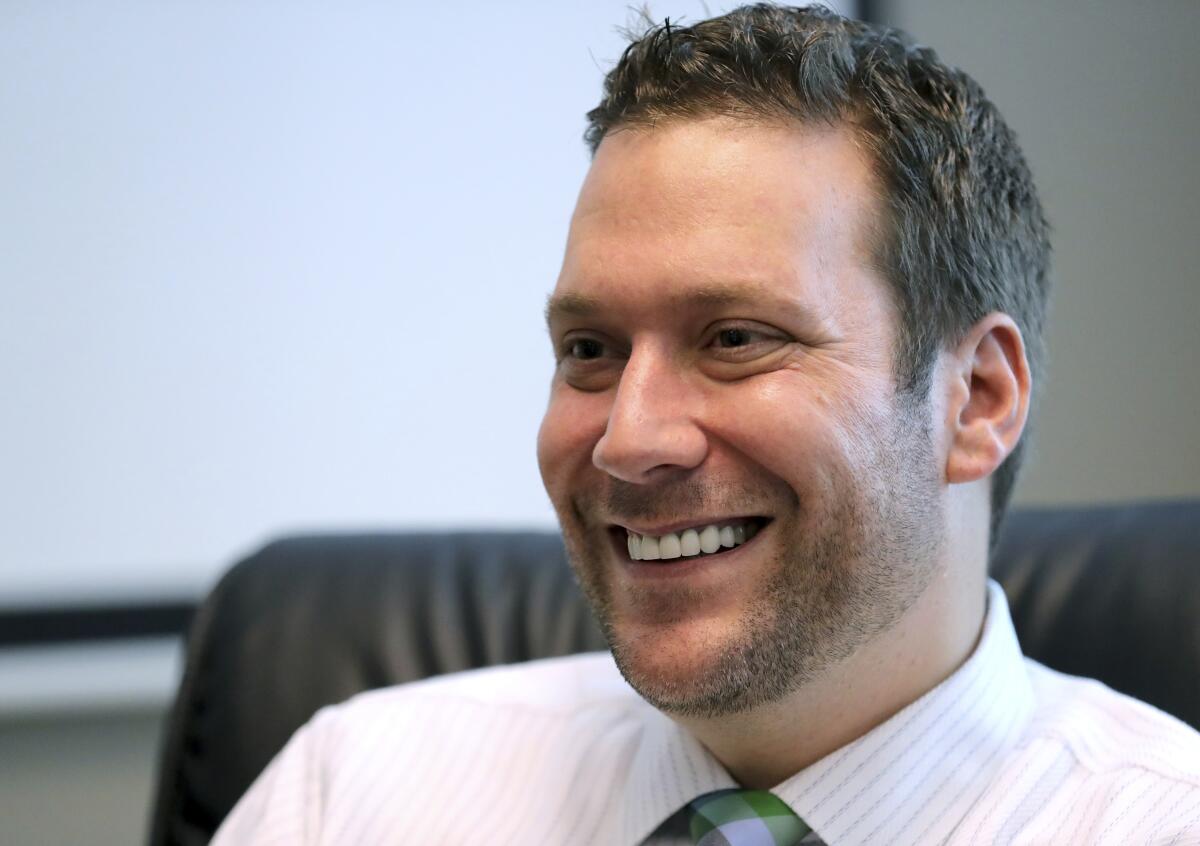 A closeup of Joel Greenberg, seated and smiling.