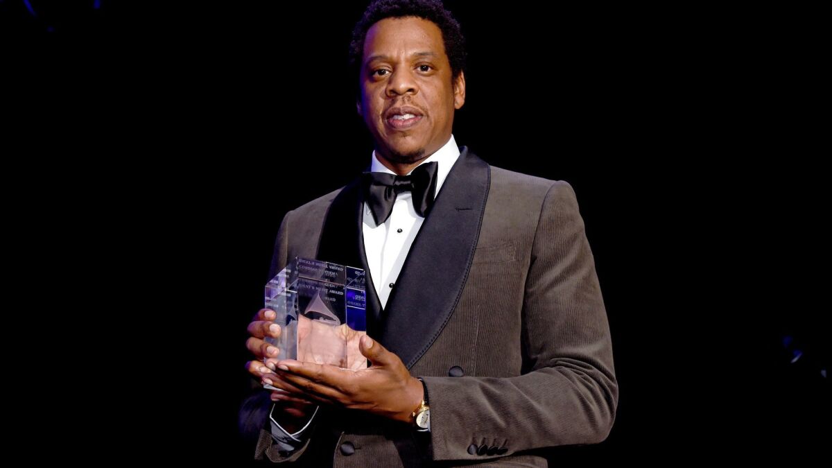 Jay-Z accepts the President's Merit Award onstage during the Clive Davis and Recording Academy's pre-Grammy gala and salute to industry icons honoring Jay-Z on Saturday.
