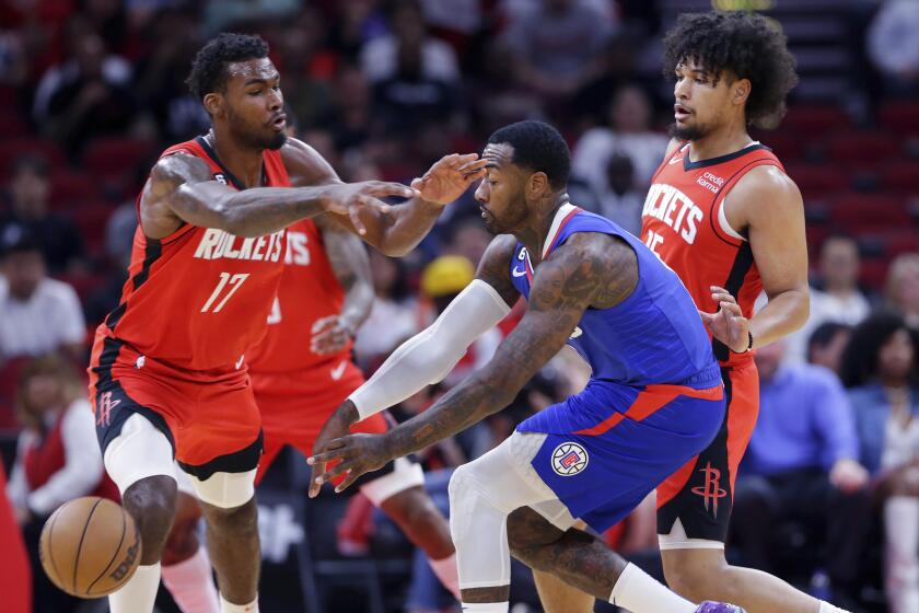 Los Angeles Clippers guard John Wall, middle, passes the ball away from Houston Rockets forward Tari Eason (17) and guard Daishen Nix, right, during the first half of an NBA basketball game Wednesday, Nov. 2, 2022, in Houston. (AP Photo/Michael Wyke)
