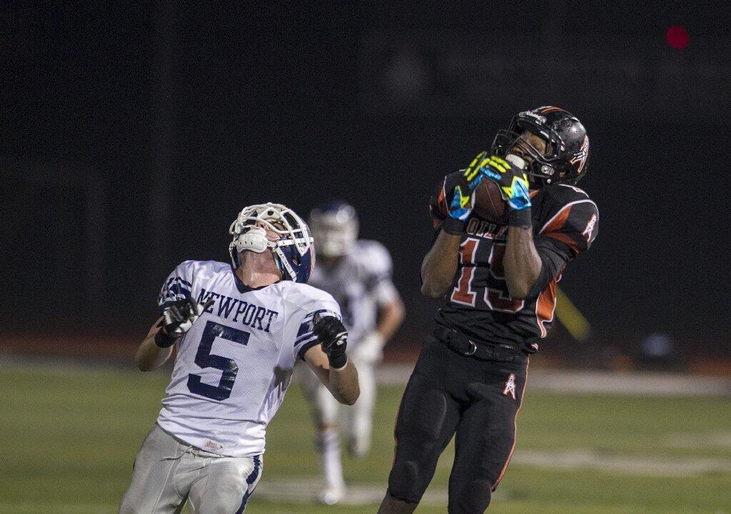 Huntington Beach's Maurice Barber makes an over-the-shoulder catch over Newport Harbor's Cory Stowell during a game on Friday.