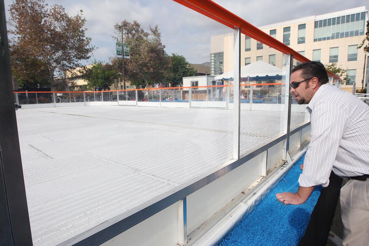 Burbank Water & Power employee Chris Allen takes a look at the ice forming on a temporary skating rink that was installed behind City Hall, photographed on Tuesday, Nov. 19, 2013.