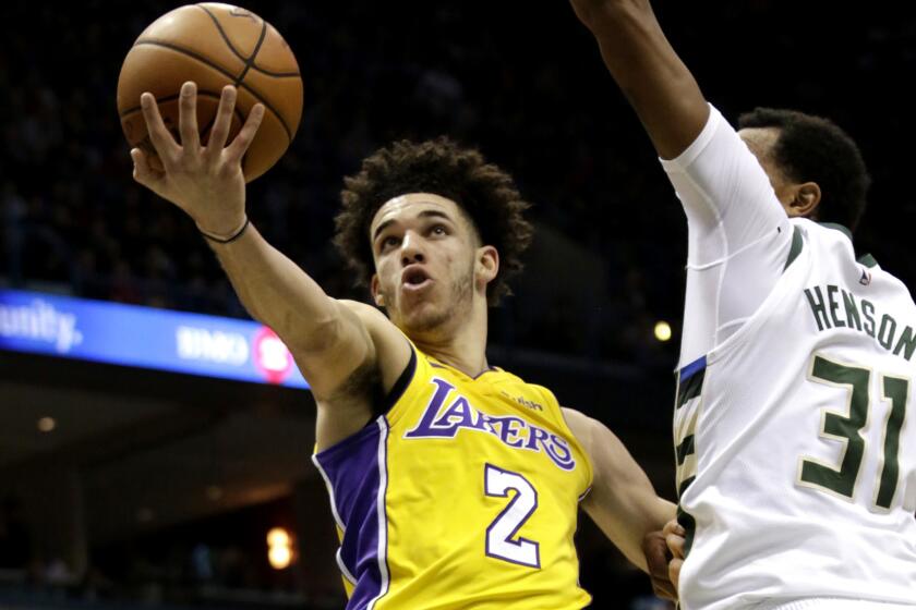 Los Angeles Lakers guard Lonzo Ball, left goes up for a basket against Milwaukee Bucks forward John Hensonm right, during the first half of an NBA basketball game Saturday, Nov. 11, 2017, in Milwaukee. (AP Photo/Darren Hauck)