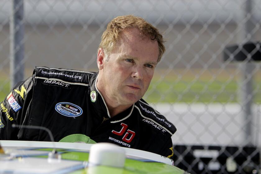 NASCAR driver Mike Wallace climbs out of his car at Daytona International Speedway on Feb. 19, 2012.