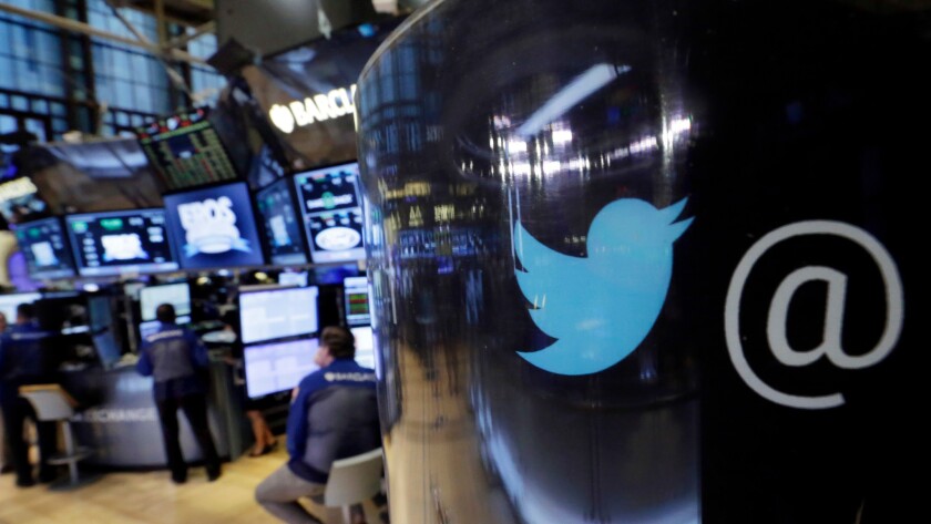 In this file photo, the Twitter logo appears on a phone post on the floor of the New York Stock Exchange.