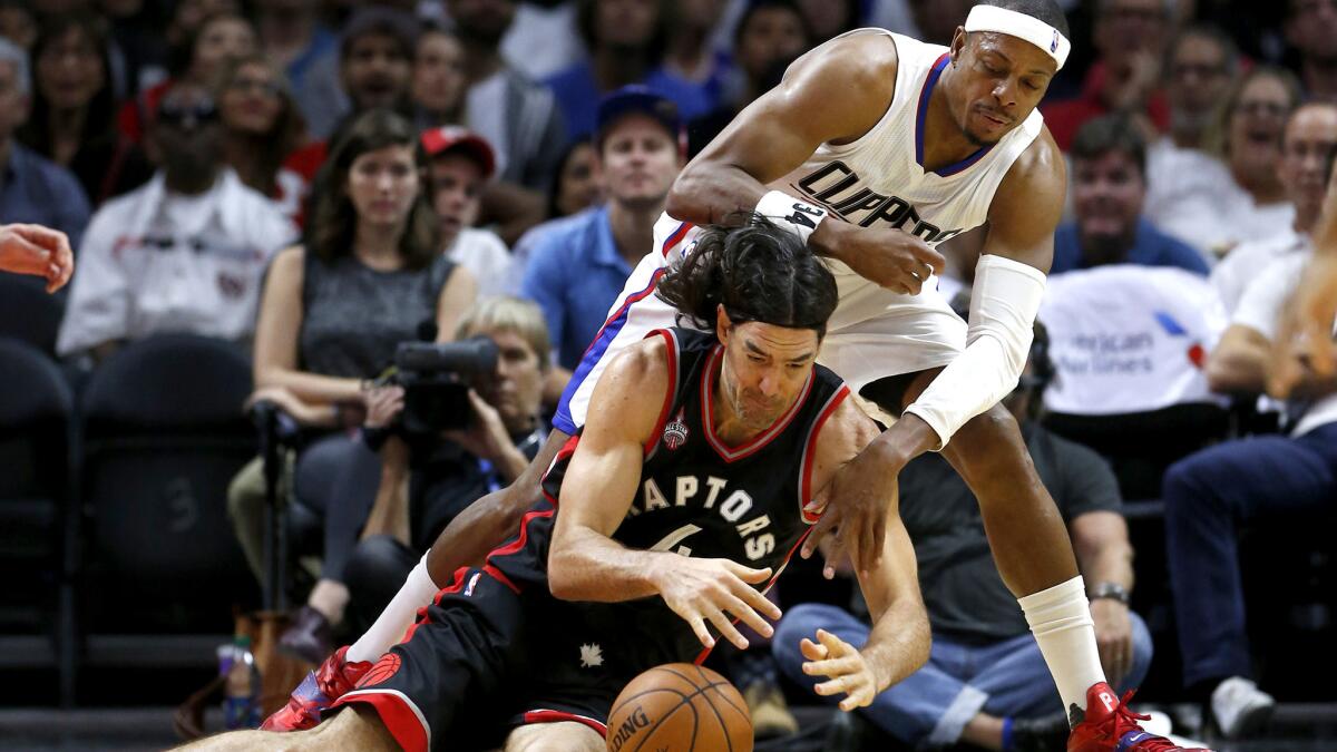 Clippers forward Paul Pierce and Raptors forward Luis Scola battle for a loose ball in the first half Sunday.
