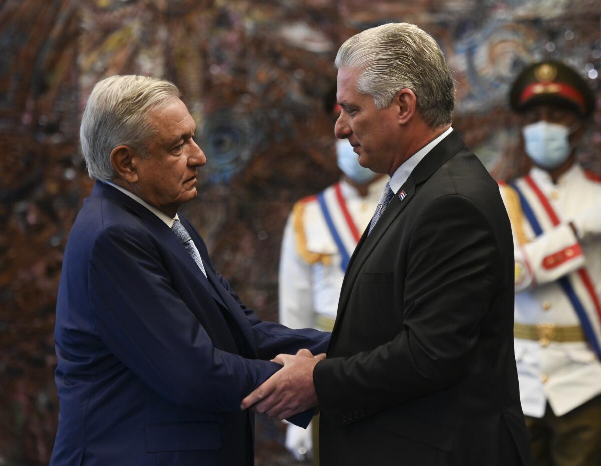 Cuban President Miguel Diaz-Canel, right, greets Mexican President Andrés Manuel López Obrador .