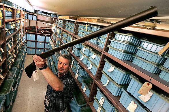 Craig Hendrickson, an operations chief for the Los Angeles County public administrator, displays a stagecoach gun stored inside a vault. Inside are high-value items, dangerous and bladed weapons belonging to people who have died and those in conservatorship whose affairs Los Angeles County is managing.
