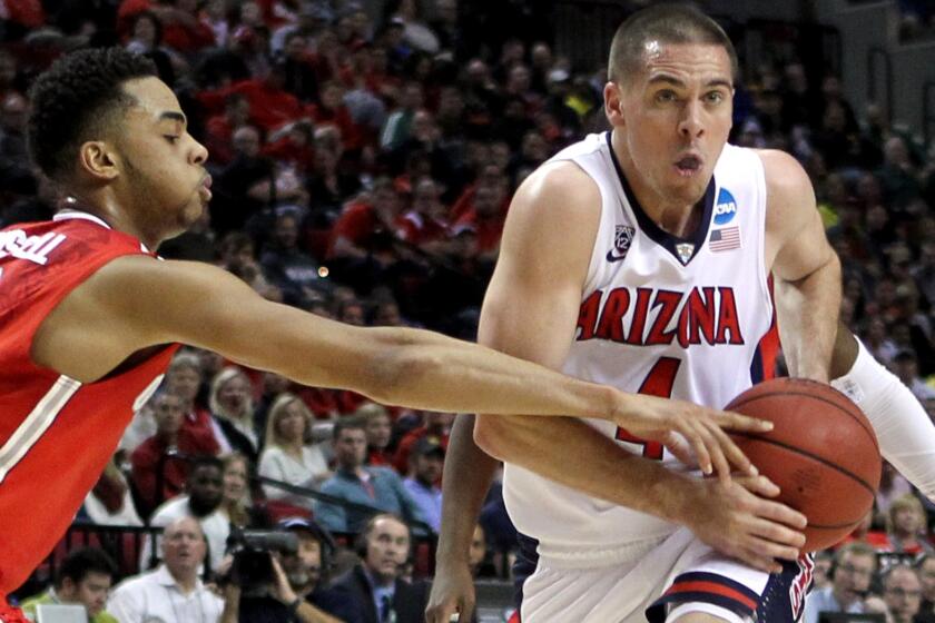 Arizona guard T.J. McConnell drives against Ohio State guard D'Angelo Russell during the Wildcats' 73-58 victory on Saturday. McConnell finished with 19 points, six rebounds, six assists and five steals.