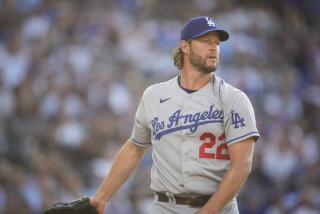 Dodgers pitcher Clayton Kershaw stands on the mound after throwing the ball and looks across the field during a game