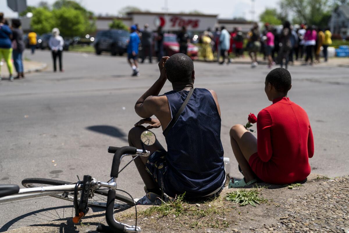 People gather outside the Tops supermarket in Buffalo, N.Y., where 10 people were killed in a mass shooting last month.