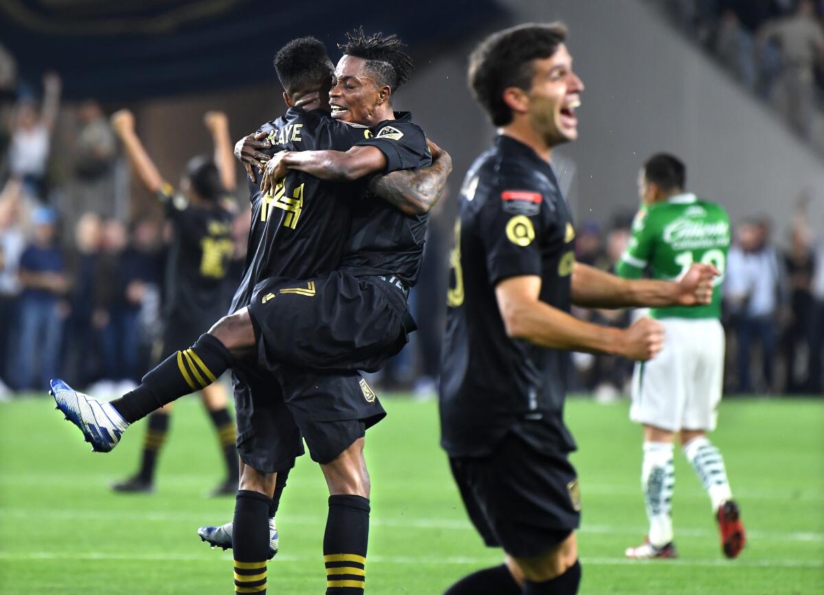 LAFC's Latif Blessing (7) jumps into the arms of teammate Mark-Anthony Kaye as they celebrate their win over León during the CONCACAF Championship League match at Banc of California on Thursday.