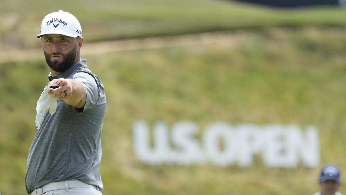 Jon Rahm points as he prepares to putt on the fourth green during a practice round for the U.S. Open.