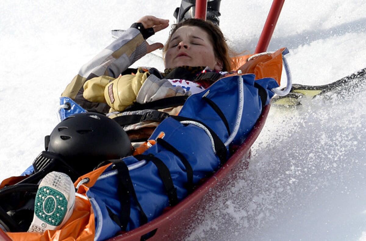 American snowboarder Jackie Hernandez is carried off the mountain on a sled by paramedics after she fell while competing in a women's snowboard cross heat on Sunday at the Rosa Khutor Extreme Park during the Sochi Olympics.