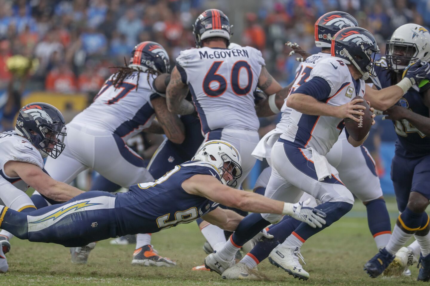Chargers defensive lineman Joey Bosa dives at the feet of Denver Broncos quarterback Case Keenum during third quarter action at Stubhub Center on Sunday.