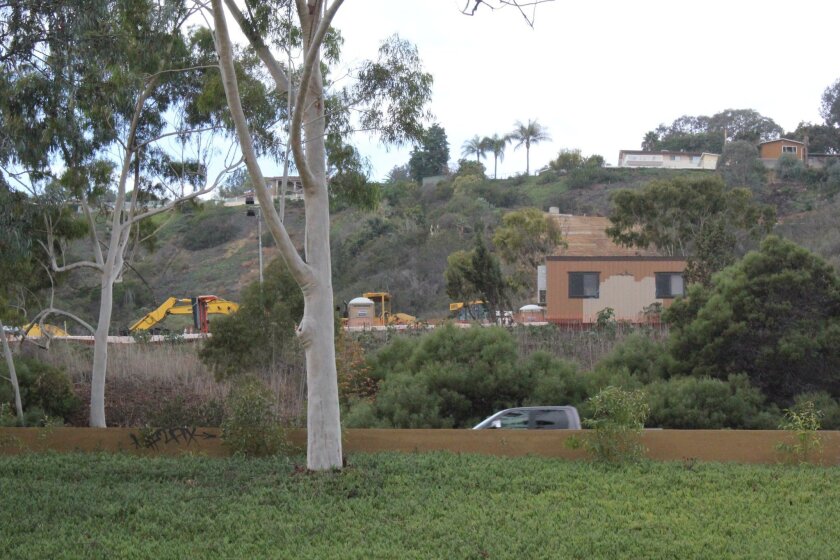 Construction crews work on a hillside below Desert View Drive, visible from Interstate 5, south of La Jolla Parkway. The San Diego Public Works Department said the outfall repair project’s aim is to stop erosion in the canyon area below.