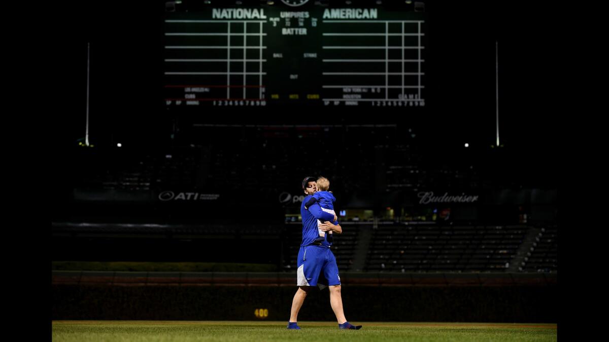 Dodgers pitcher Clayton Kershaw carries his son Charlie after his team won the National League pennant in Game 5 of the NLCS at Wrigley Field.