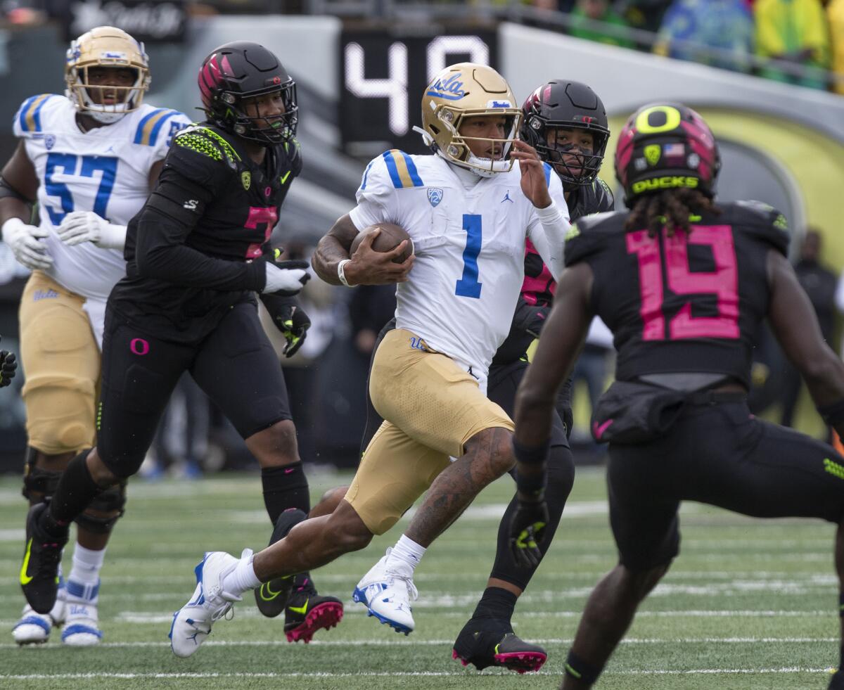 UCLA 's Dorian Thompson-Robinson (1) runs against the Oregon defense