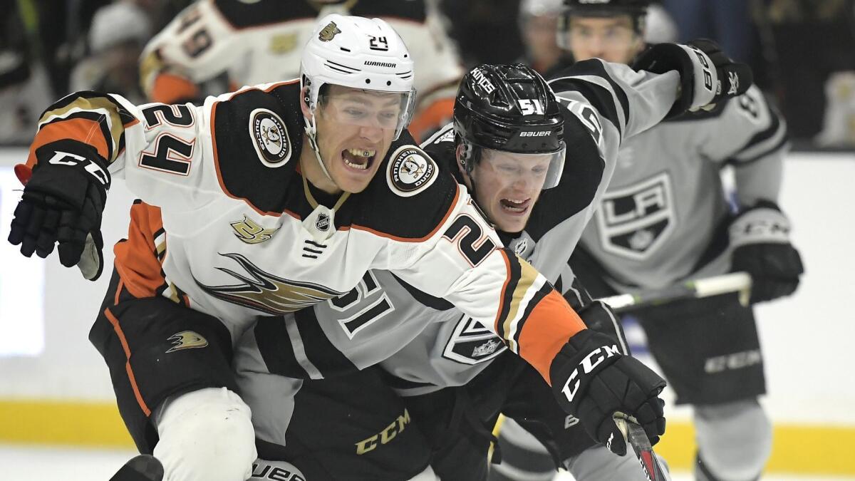 Ducks center Carter Rowney, left, and Kings left wing Austin Wagner battle for the puck during Saturday's game.