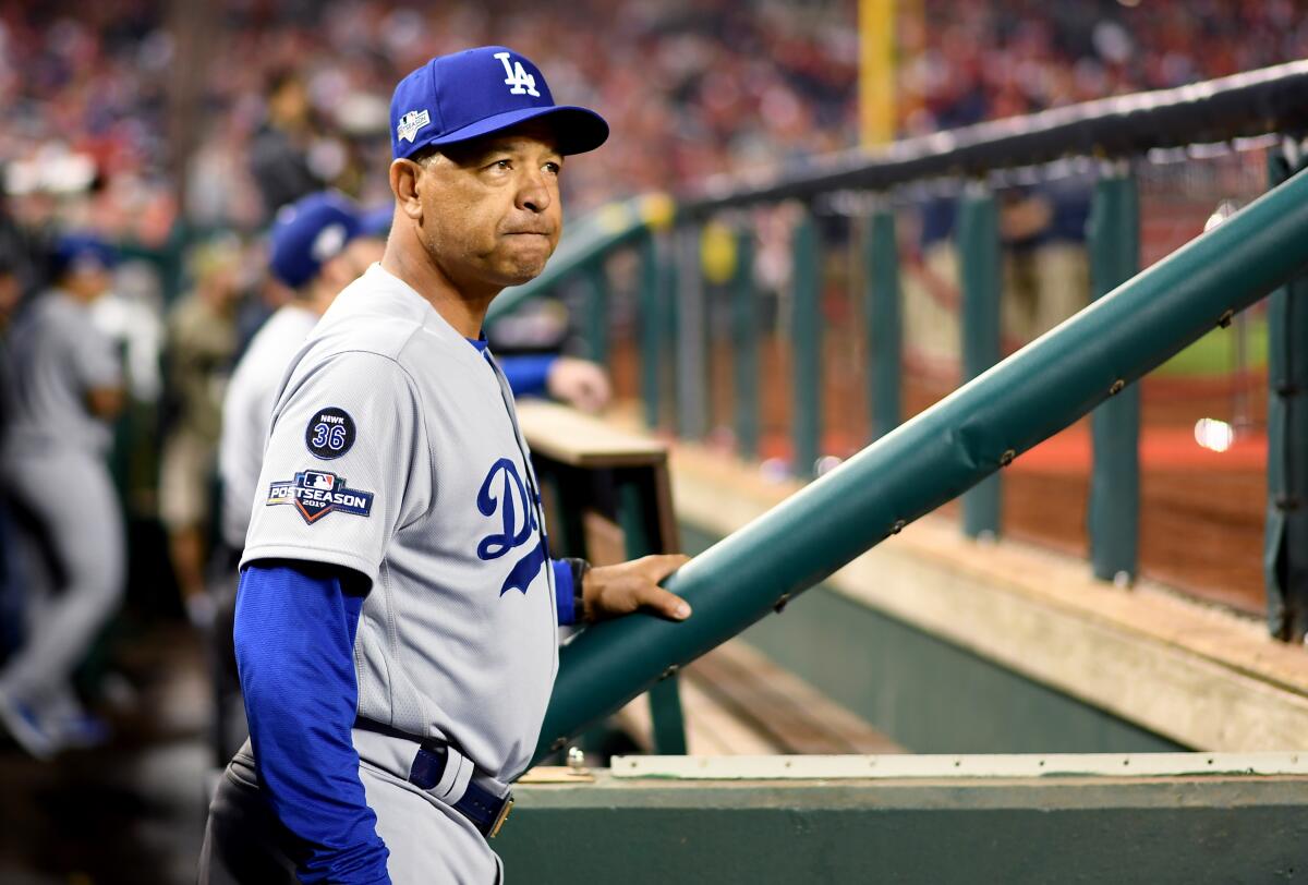 Dodgers manager Dave Roberts stands in the dugout before Game 3 of the NLDS at Nationals Park.