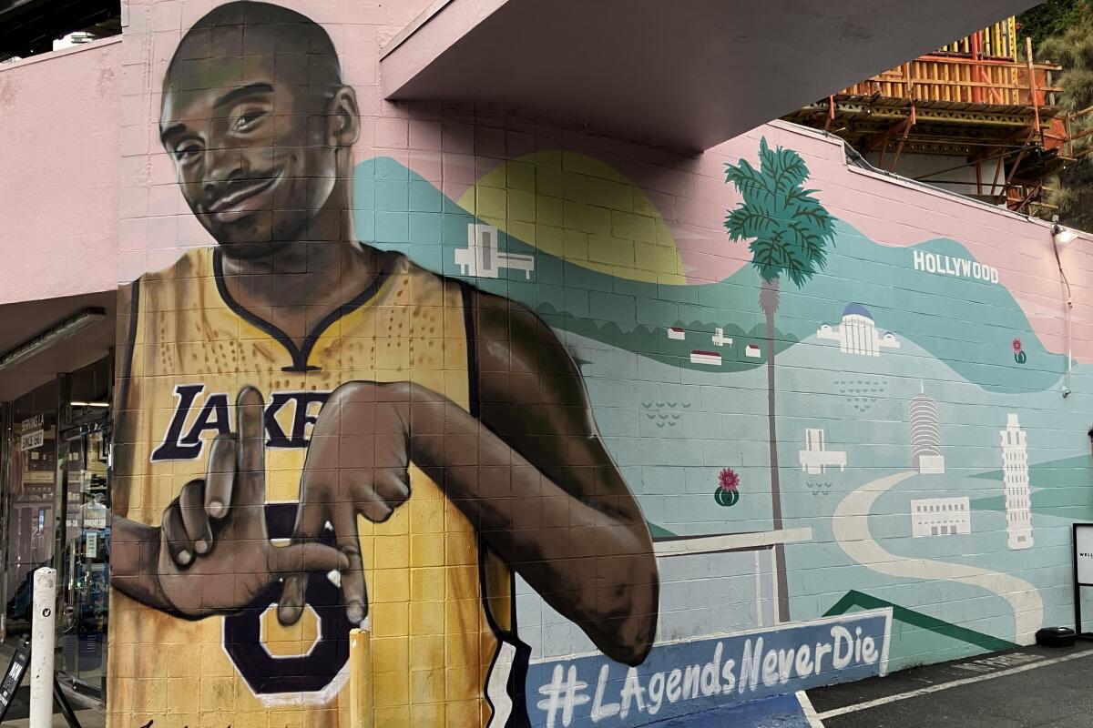 Kobe Bryant flashes an L.A. sign with his hands in a mural outside of Pink Dot on the Sunset Strip.
