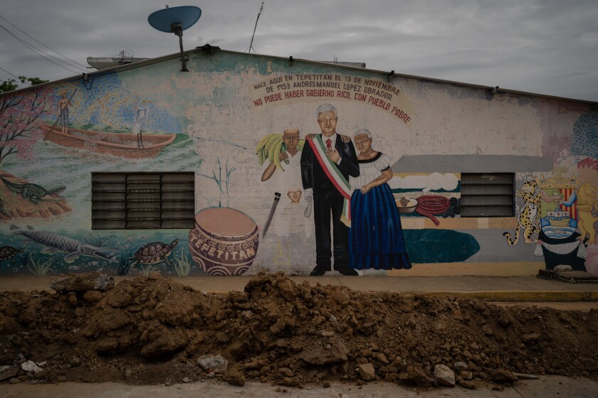 View of the house with a painted mural by Andres Manuel Lopez Obrador and a white-haired woman.