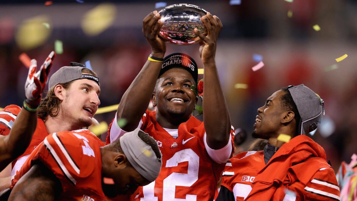 Ohio State quarterback Cardale Jones, center, hold the Big Ten championship trophy after last week's 59-0 win over Wisconsin.