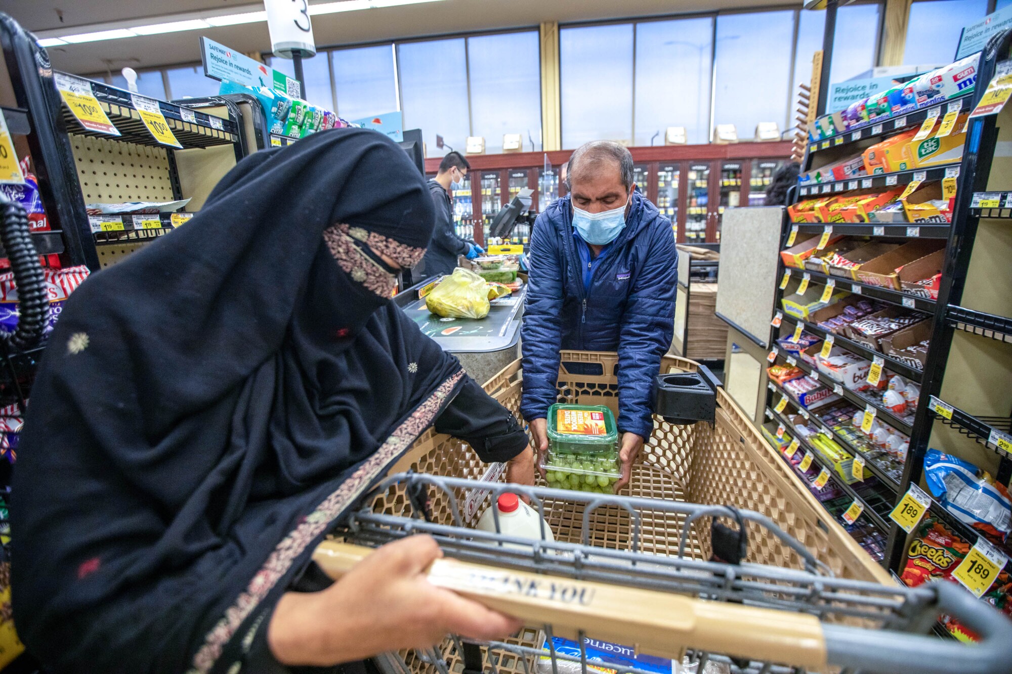 Afghan refugees Abdul Matin Qadiri and his wife shop for groceries.