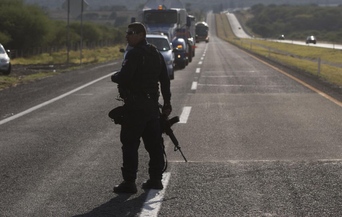 Un policía estatal detiene el tráfico en una carretera del estado de Michoacán, en el oeste de México.